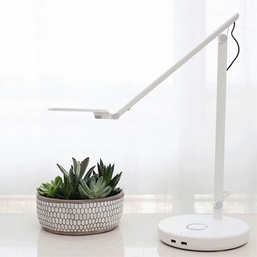 Humanscale Nova task light in white on desk with plant